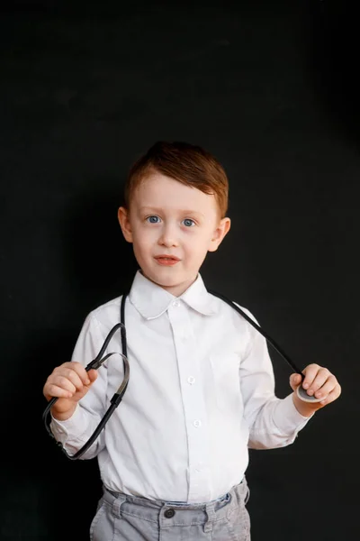 Улыбающийся Мальчик Медицинской Форме Играет Стетоскопом — стоковое фото