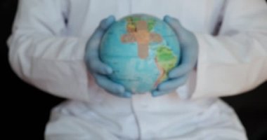 Mavi arka planda izole edilmiş tıbbi elbise, steril yüz maskesi eldivenli erkek doktor görüntüsü. Salgın hastalıklar.