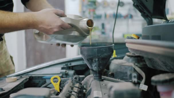 Údržba vozu servisní mechanik nalití nové mazivo olej do motoru auta. Proudí čerstvý nový čistý syntetický olej do motoru auta. Vyměňte motorový olej v autě.