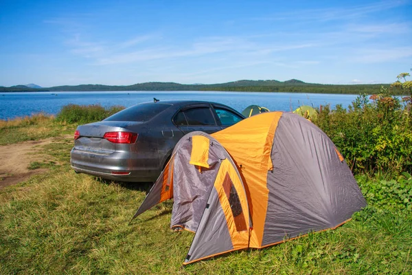 Passeio em família. carro e tenda na margem de um lago de montanha. riz — Fotografia de Stock