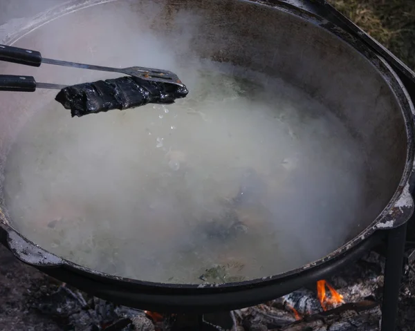 The process of cooking fish soup in a cauldron on the street. so — Stock Photo, Image