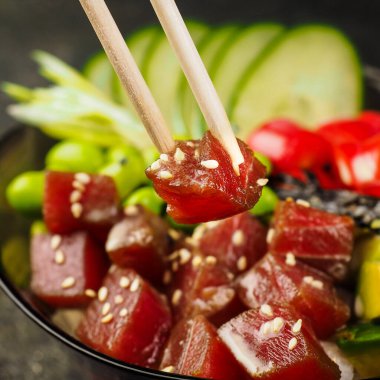 Pirinç ve kinoa kasesi. Yemek çubukları ve bir parça somon ve ton balığının yakın plan fotoğrafı. Deniz ürünleri, Hawaii mutfağı. Modern moda menü yemeği