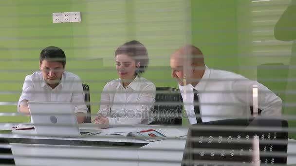 Team van drie Kaukasische mensen uit het bedrijfsleven in de stad kleren bijeen in een modern kantoor directiekamer. Ze zijn het bespreken van ideeën voor hun zakelijke ontwikkeling. — Stockvideo