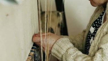 Halı dokuma. Türk kadını bir manuel sallama makinesi ile barış hakiki deve yün ile bir halı dokuma. 