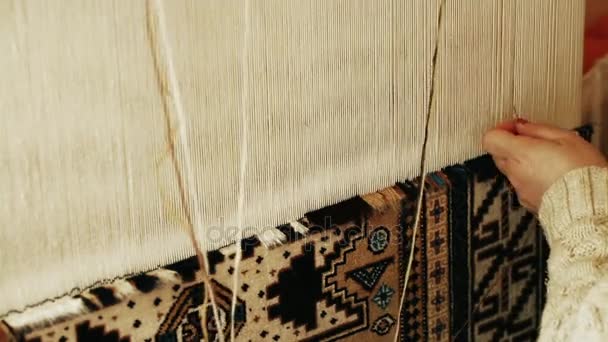 Ковроткачество. Турецкая женщина плетет ковёр с миром из натуральной верблюжьей шерсти с помощью ручной машины для размахивания . — стоковое видео