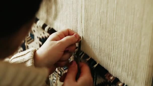 Tapijt weven. Turkse vrouw weven een tapijt met vrede van echte kameel wol met een handmatige wuivende machine. — Stockvideo