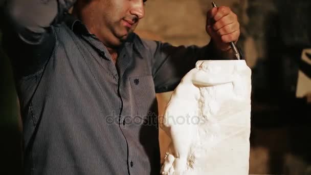 Скульптор работает со статуэткой из мрамора — стоковое видео