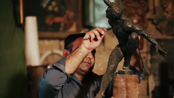 Skulptör arbetar på ett monument gjorda av lera — Stockvideo
