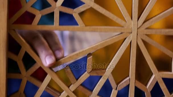 The master of stained glass puts pieces of cropped multicolored glass into wooden frames creating a composition. Azerbaijan old art. — Stock Video