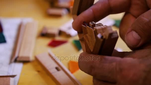 O mestre de vitrais coloca pedaços de vidro multicolorido cortado em quadros de madeira, criando uma composição. Azerbaijão arte antiga . — Vídeo de Stock