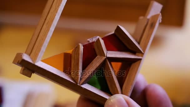 Il maestro del vetro colorato mette pezzi di vetro multicolore ritagliato in cornici di legno creando una composizione. Azerbaigian arte antica . — Video Stock