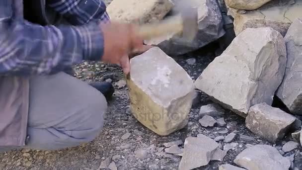 Muratore tagliando un blocco di granito con mazza. Pietre di lancio per la costruzione. Lavoratore di pietra con martello Sledge colpire blocco di cemento. Scultore azero Pietra da intaglio. Scalpellino intaglio — Video Stock