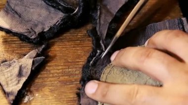 Şapka-maker çalışır. Verme süreci bir şapka. Astrahan şapka orijinal yün ve deri. Astrahan şapka ve keçe pelerin. Şapka maker makası kavramı ahşap doku.
