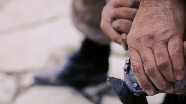 Tailler, nettoyer, façonner et couper le tissu de semelle excédentaire des sabots du cheval à l'aide d'un couteau dans une forge. Fer à cheval fabricant fer à cheval le cheval. Azerbaïdjan — Video