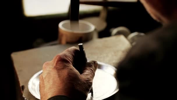 Traditionele tinnegieter werk. Koper smith maakt embossing artefacten van koper. Het ontwerpen van gebruiksvoorwerpen, de leeftijds oude kunst van het knutselen waren. Kopergravure. Souvenirs. Schieten close-up koper smith werk. — Stockvideo