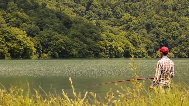 Vliegvissen. Jonge visser staat door het meer vliegen en besteedt zijn dag vliegvissen. Vliegvissen van lake in Azerbeidzjan. — Stockvideo