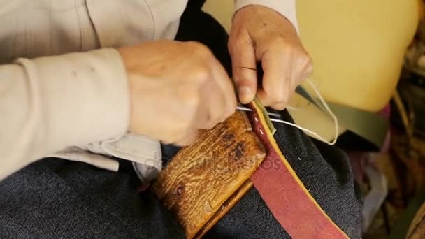 Saddler. Fabrication de selles. Artisanat maroquinier au travail dans son atelier. Cuir artisanal. Fabrication de selles. Vieil art vintage. Cuir à coudre traditionnel jusqu'au point de selle. Azerbaïdjan vieil art . — Video