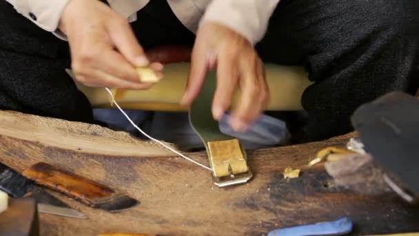 Z'n. Zadel vervaardiging. Lederen goederen ambachtsman op het werk in zijn werkplaats. Artisan leder. Zadel crafting. Oude vintage art. De leer van het traditionele naaien tot het punt van het zadel. Azerbeidzjan oude kunst. — Stockvideo