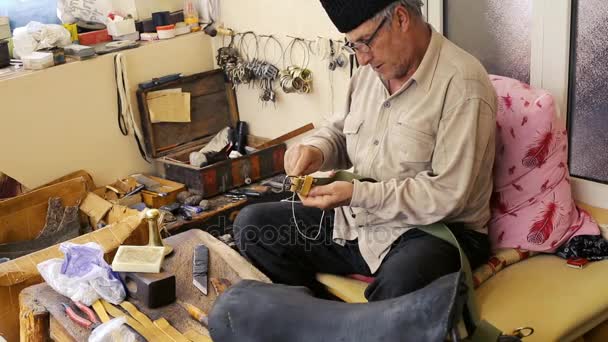 Saddler. Fabricación de sillines. Artesano de cuero en el trabajo en su taller. Cuero Artesanal. Elaboración de sillas. Antiguo arte vintage. Cuero de coser tradicional hasta el punto de silla de montar. Azerbaiyán arte antiguo . — Vídeos de Stock