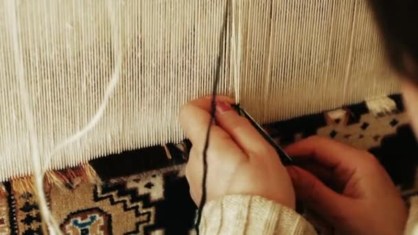 Carpet weaving. Turkish woman weaving a carpet with peace of genuine camel wool with a manual waving machine. — Stock Video