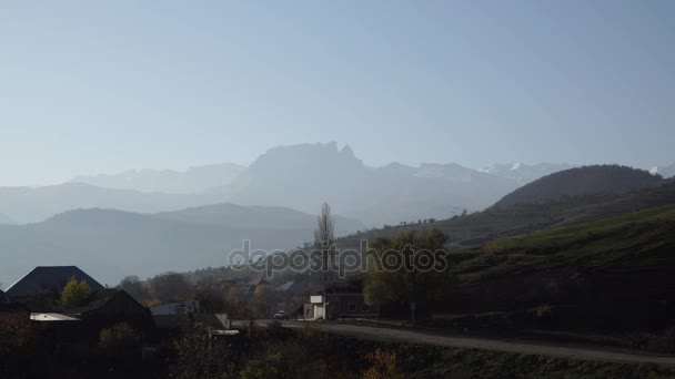 कोकेशियान पर्वत। गांव पहाड़ों के नीचे है। महान काकेशस रेंज — स्टॉक वीडियो