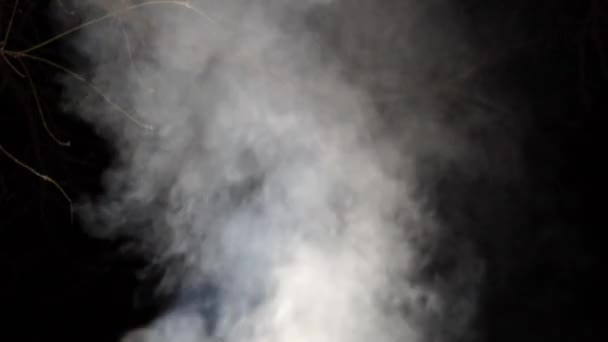 Humo blanco se levanta en la noche sobre un fondo negro — Vídeo de stock