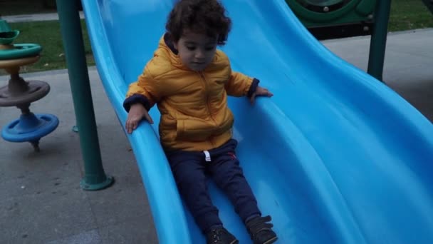 Niño pequeño está jugando en el patio de recreo — Vídeos de Stock