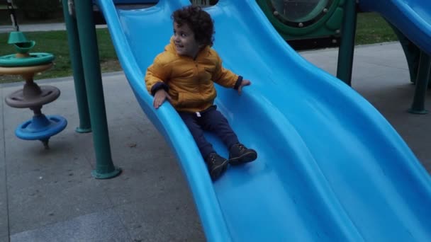 Niño pequeño está jugando en el patio de recreo — Vídeo de stock