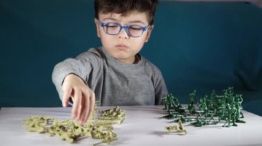beş yaşında bir çocuk oyuncak askerlerle oynayan