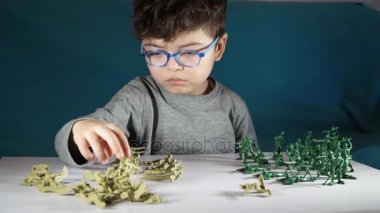beş yaşında bir çocuk oyuncak askerlerle oynayan