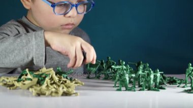 beş yaşında bir çocuk oyuncak askerlerle oynayan