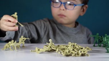 beş yaşında bir çocuk oyuncak askerlerle oynayan