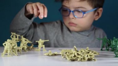 beş yaşında bir çocuk oyuncak askerlerle oynayan