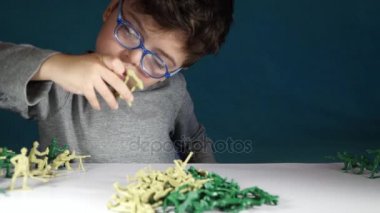 beş yaşında bir çocuk oyuncak askerlerle oynayan