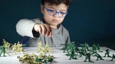 beş yaşında bir çocuk oyuncak askerlerle oynayan