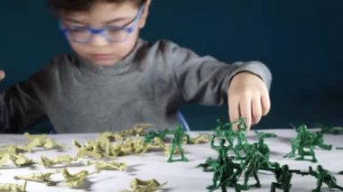 beş yaşında bir çocuk oyuncak askerlerle oynayan