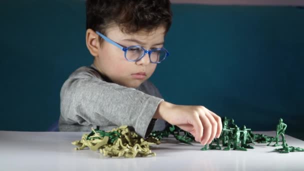 Niño de cinco años jugando con soldados de juguete — Vídeos de Stock