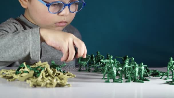 Niño de cinco años jugando con soldados de juguete — Vídeo de stock