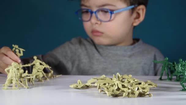 Fem-årig pojke leker med tennsoldater — Stockvideo