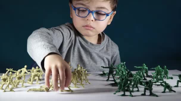 Niño de cinco años jugando con soldados de juguete — Vídeos de Stock