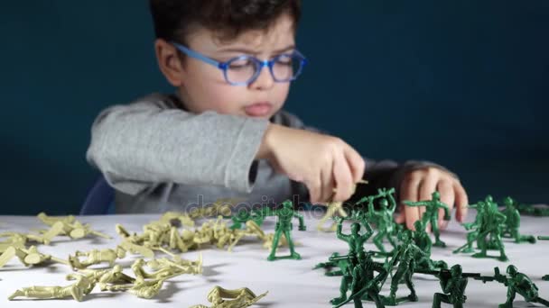 Niño de cinco años jugando con soldados de juguete — Vídeo de stock