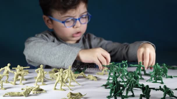 Five year old boy playing with toy soldiers — Stock Video