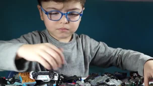 П'ятирічний хлопчик грає з іграшковими машинами — стокове відео