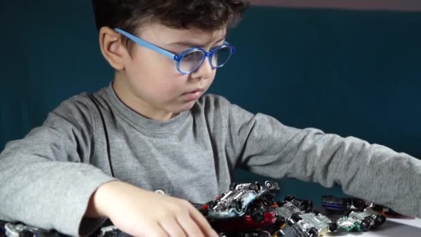 Menino de cinco anos brincando com carros de brinquedo — Vídeo de Stock