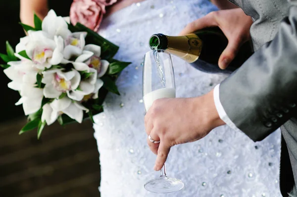 Bräutigam und Braut fühlen sich zu Champagner hingezogen — Stockfoto