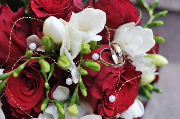 Wedding bridal bouquet and two gold wedding rings — Stock Photo, Image