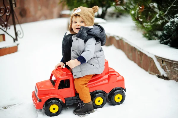 Мальчик и игрушечная машина зимой — стоковое фото