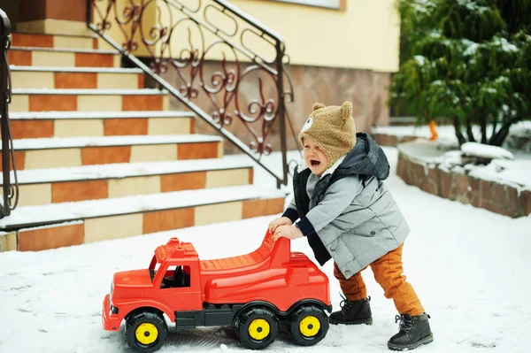 Baby boy and toy car in winter — Stock Photo, Image