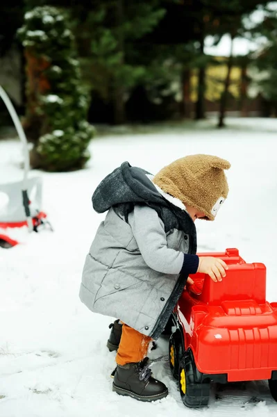 Мальчик и игрушечная машина зимой — стоковое фото