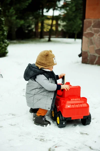 Baby jongen en speelgoed auto in de winter — Stockfoto